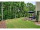 Lush backyard with green lawn, patio area, flower bed, and treed backdrop at 1680 Laleiah Dr, Cumming, GA 30041