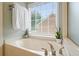 Relaxing bathroom with a soaking tub, window, and natural light at 1680 Laleiah Dr, Cumming, GA 30041