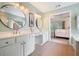 Bathroom with a double sink vanity, round mirrors, and tile flooring at 1680 Laleiah Dr, Cumming, GA 30041