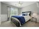 Neutral bedroom with bed, side table, grey walls, and carpet flooring at 1680 Laleiah Dr, Cumming, GA 30041