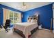 Bright blue bedroom with a desk and a bed with storage drawers at 1680 Laleiah Dr, Cumming, GA 30041