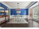 Elegant dining room with blue walls, a modern chandelier, and ample natural light at 1680 Laleiah Dr, Cumming, GA 30041