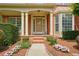 Charming front porch with decorative columns and flower beds leading to the front door at 1680 Laleiah Dr, Cumming, GA 30041