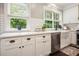 Bright kitchen features white cabinetry, stainless dishwasher, and farm sink at 1680 Laleiah Dr, Cumming, GA 30041