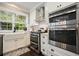 Bright kitchen with stainless appliances, white cabinets, and tiled backsplash at 1680 Laleiah Dr, Cumming, GA 30041