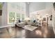 Open living room with large windows and hardwood floors is adjacent to the modern kitchen at 1680 Laleiah Dr, Cumming, GA 30041