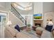 Open-concept living room with fireplace and stairway leading to upper level at 1680 Laleiah Dr, Cumming, GA 30041