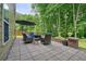 Stone patio features comfortable outdoor seating with a fire pit, creating a relaxing atmosphere with backyard views at 1680 Laleiah Dr, Cumming, GA 30041