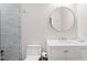 Cozy bathroom featuring a white vanity with round mirror, toilet, and partial glass-enclosed shower at 309 Mcdaniel Pl, Canton, GA 30115