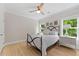 Bedroom features a metal bed frame, wood floors, large windows for natural light, and side tables with lamps at 309 Mcdaniel Pl, Canton, GA 30115