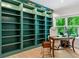 Bright home office featuring built-in bookshelves, hardwood floors, and a sun-filled window view at 309 Mcdaniel Pl, Canton, GA 30115