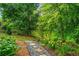 Landscaped backyard walkway leading to a peaceful pond, creating a serene outdoor oasis at 309 Mcdaniel Pl, Canton, GA 30115