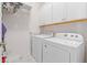 Functional laundry room with washer, dryer, and overhead cabinets for ample storage at 309 Mcdaniel Pl, Canton, GA 30115