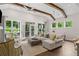 Bright living room with vaulted ceilings, wooden beams, ample seating and access to outdoor screened deck at 309 Mcdaniel Pl, Canton, GA 30115