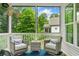 Relaxing screened porch featuring wicker furniture, stylish decor, and a serene outdoor view at 309 Mcdaniel Pl, Canton, GA 30115