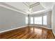 Bedroom features hardwood floors, tray ceilings, a ceiling fan and bright windows at 3885 Lake Juliette Dr, Buford, GA 30519