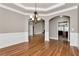 Formal dining room with hardwood floors, coffered ceiling, and a seamless transition to kitchen at 3885 Lake Juliette Dr, Buford, GA 30519