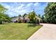 Landscaped lawn and paved driveway leading to a charming home with mature trees at 3885 Lake Juliette Dr, Buford, GA 30519