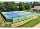 Outdoor community tennis courts with well-maintained green and blue surface, enclosed by black fencing at 3885 Lake Juliette Dr, Buford, GA 30519