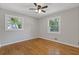 Light-filled bedroom with hardwood floors, two windows, and neutral wall colors at 4345 Sasanqua Ct, Tucker, GA 30084