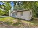An eye-level view of a white brick house, surrounded by trees and lush greenery at 4345 Sasanqua Ct, Tucker, GA 30084