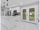 A modern, all-white kitchen with stainless steel appliances, marble countertops, and light tile floors at 4345 Sasanqua Ct, Tucker, GA 30084