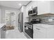 Updated kitchen featuring stainless steel appliances, marble backsplash and white cabinetry at 4345 Sasanqua Ct, Tucker, GA 30084