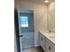 Bathroom featuring a double vanity, white cabinets, and a view into the bedroom at 57 Longhorn Way, Auburn, GA 30011
