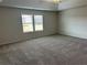 Large bedroom with tray ceiling, plush carpeting, and bright, natural light from large windows at 57 Longhorn Way, Auburn, GA 30011