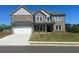 Beautiful two story home with gray brick and gray siding, professionally landscaped lawn and two car garage at 57 Longhorn Way, Auburn, GA 30011