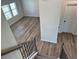 Hallway features wood flooring, staircase, a window, and a neutral color palette at 57 Longhorn Way, Auburn, GA 30011
