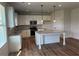 Kitchen boasts stainless steel appliances, island and granite countertops at 57 Longhorn Way, Auburn, GA 30011