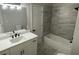 Modern bathroom featuring a tub/shower combo, updated vanity, sleek fixtures, and neutral color palette at 5920 Findley Chase Dr, Johns Creek, GA 30097