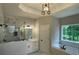 Relaxing bathroom boasting marble tile, a soaking tub, a frameless shower, and a double vanity at 5920 Findley Chase Dr, Johns Creek, GA 30097