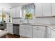 Bright kitchen features white cabinets, granite countertops, stainless steel appliances, and a view of the backyard at 140 Discovery Lake Dr, Fayetteville, GA 30215