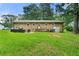View of the back exterior with a lush green lawn and outdoor patio seating area at 165 Wellington Dr, Mcdonough, GA 30252