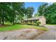 View of charming brick home with well-kept landscaping, trees and a wide driveway at 165 Wellington Dr, Mcdonough, GA 30252