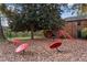 Whimsical backyard playground with a large shade tree, red climbing equipment and decorative mushroom seats at 3083 Colonial Way # E, Atlanta, GA 30341