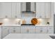 Well-lit kitchen featuring white cabinets, stainless steel hood, and a gas cooktop at 4020 Connolly Ct, Roswell, GA 30075