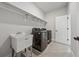 Well-lit laundry room featuring a large sink, modern washer and dryer, and ample shelving for storage at 4020 Connolly Ct, Roswell, GA 30075