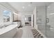 The main bathroom has a soaking tub, large window, glass shower with seat, and dual sink vanity at 4020 Connolly Ct, Roswell, GA 30075