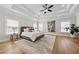 Spacious primary bedroom featuring a tray ceiling, large windows, hardwood floors, and stylish decor at 4020 Connolly Ct, Roswell, GA 30075