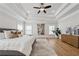 Elegant primary bedroom boasting hardwood floors, a decorative tray ceiling, ample natural light, and sophisticated furnishings at 4020 Connolly Ct, Roswell, GA 30075