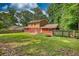 Home with a brick exterior and a spacious green backyard surrounded by a wooden fence at 1177 Castle Way Way, Norcross, GA 30093