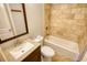 A bathroom featuring a tiled shower and tub, toilet, sink, vanity, and a framed mirror at 1177 Castle Way Way, Norcross, GA 30093