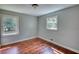 Neutral bedroom featuring hardwood floors, two windows offering ample natural light, and painted walls at 1177 Castle Way Way, Norcross, GA 30093