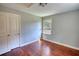 Empty bedroom with hardwood floors, fresh paint, closet, and a window providing natural light at 1177 Castle Way Way, Norcross, GA 30093