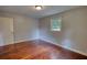 A bedroom with hardwood floors, neutral walls and a single window providing natural light at 1177 Castle Way Way, Norcross, GA 30093