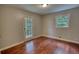 Bright bedroom with hardwood flooring, a window, and a door with glass panels at 1177 Castle Way Way, Norcross, GA 30093
