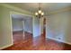 Dining room view with decorative lighting, trim work, and wood floors leading to the living area and kitchen at 1177 Castle Way Way, Norcross, GA 30093